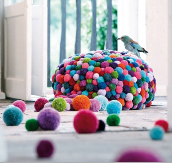 a colorful pompom pouf will accent your space and make it cheerful, you can DIY this piece easily