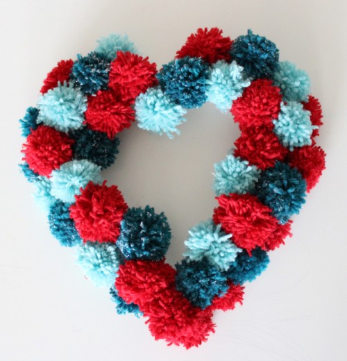 A colorful pompom heart shaped wreath is a nice decoration for Valentine's Day or just for romantic decor