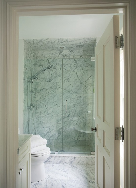 a laconic white marble bathroom with a shower space and a vanity - you won't need more than that