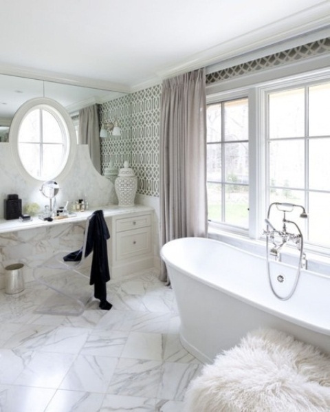 a glam marble bathroom with a tiled floor and wall, a chic bathtub, a mirror wall and faux fur