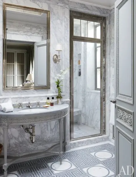 a luxurious Greece-inspired bathroom with white marble, metallic touches and patterns