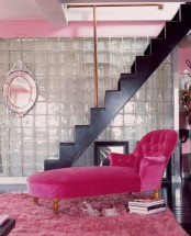 a grey painted glass wall, a black staircase and a hot pink lounger and a pink rug are a chic and bold combo