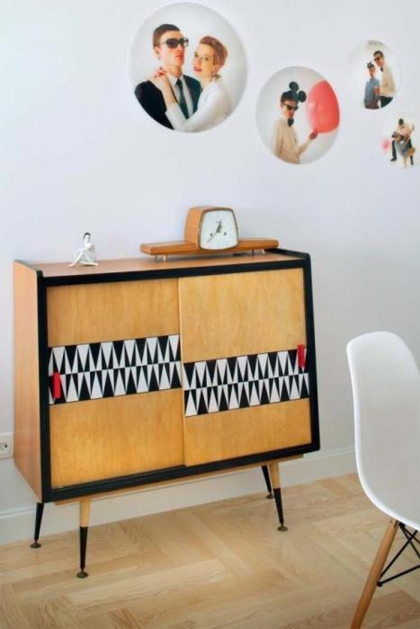 a whimsical light-stained mid-century modern cabinet with sliding doors, geometric detailing and tall legs is a stylish idea for a modern space