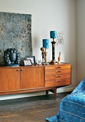 a rich-stained mid-century modern credenza with whimsical decor – candles, artwork and a couple of photos is a lovely idea