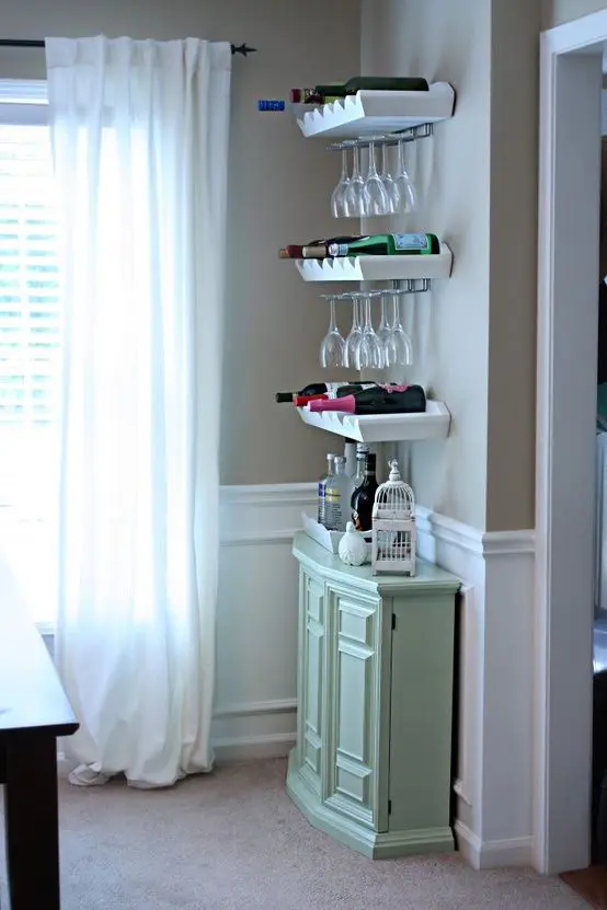 A small mint colored bar, open shelves for holding bottles and glasses form a cool home bar that doesn't take much space