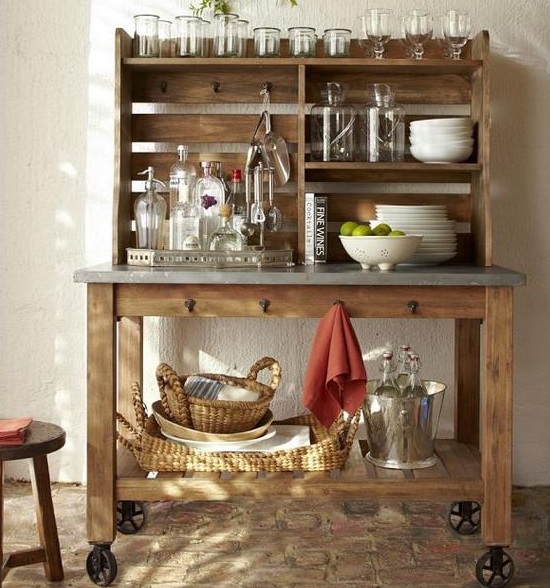 a rustic home bar made of wood and concrete, with glasses, bottles and baskets for storage