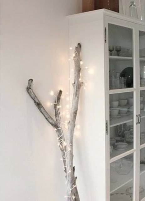 branches wrapped with lights are a nice Christmas tree alternative that can be used in any space