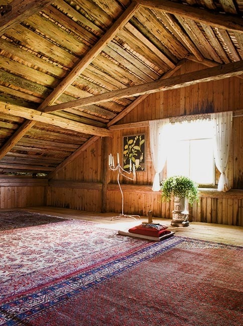 an attic boho chic meditation space with layered rugs and some pillows