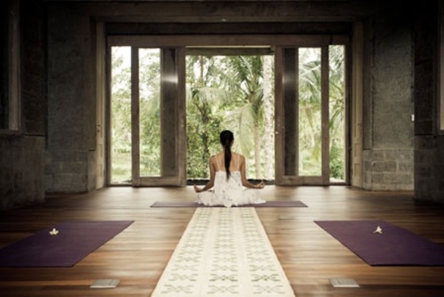 a contemporary meditation room with colorful rugs and a glazed wall for much light