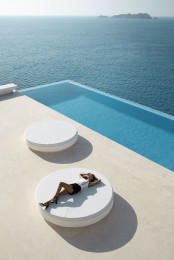an ultra-minimalist terrace with a long and narrow pool, with white round beds and a fantastic sea view – who needs more than that