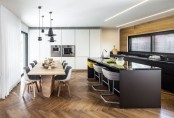 a contemporary black kitchen with sleek cabinets, a large black kitchen island with modern stools to have bites here