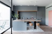 a minimalist grey kitchen with sleek cabinets, a large kitchen island with a butcherblock countertop, matchign cork stools to eat here