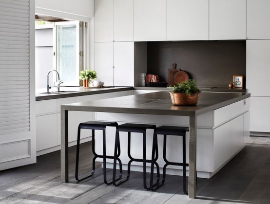 a minimalist white kitchen with sleek and plain cabinets, concrete countertops and a backsplash, a kitchen island with black stools to eat here