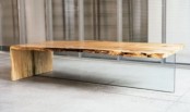 a modern coffee table with a glass base and a wooden waterfall tabletop is a stylish idea for a modern living room