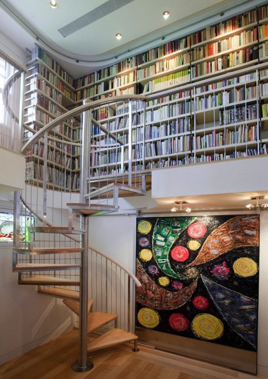 a modern library with bookshelves built-in on the second floor, a bold abstract painting - just add a chair and voila