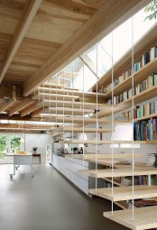 light-colored wooden bookshelves mounted to the wall next to the staircase – read sitting on the steps