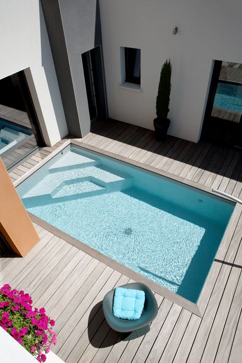 modern wooden deck with a small outdoor pool