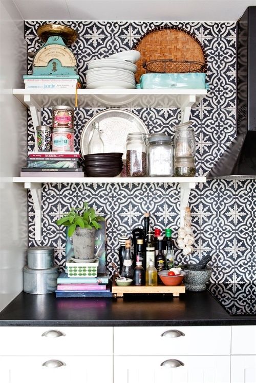 a cool black and white kitchen with metallic knobs and black and white Moroccan tile backsplash that brings pattern and interest to the space