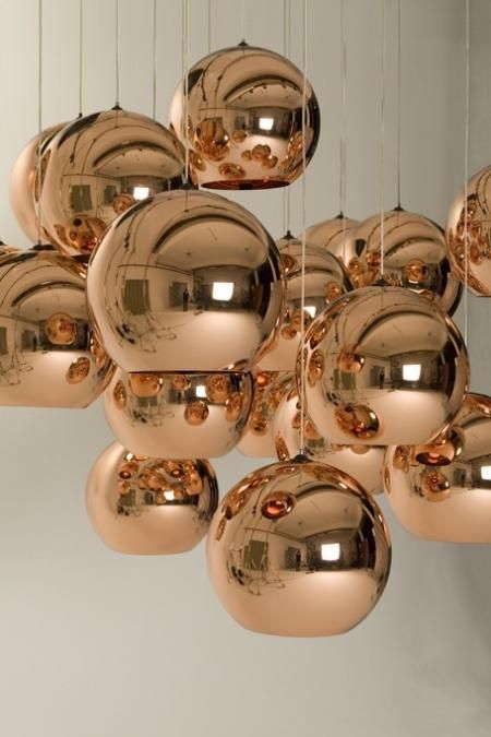 beautiful copper sphere pendant lamps hanging in a cluster are amazing for a modern or contemporary space, they add chic and a soft touch of color