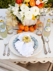 elegant white and blue patterned porcelain and bright blooms and fruit are a lovely idea for a Mother’s Day tablescape