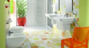 a neon yellow bathroom with a bold tile floor, wiht orange accents feels like spring or summer and is very inviting