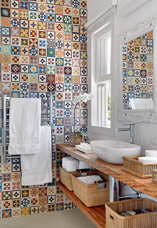 A bold multi color bathroom with bright printed tiles accent wall, a floating open vanity and white appliances