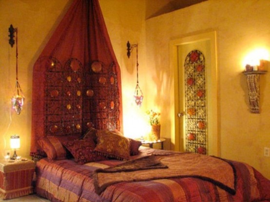 a warm-colored Moroccan bedroom with hanging lanterns, a mosaic door and colorful textiles