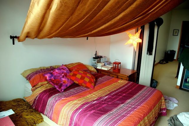 A Moroccan bedroom done with extra bright textiles and a canopy, lanterns and a star shaped lamp