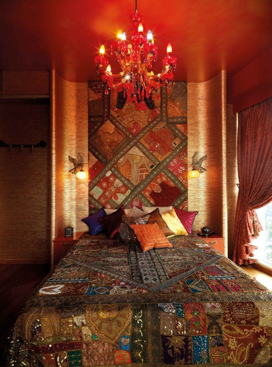 super colorful and printed textiles, a red chandelier and pillows create a unique and bright sleeping space