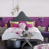 a Moroccan-inspired leather bed, lanterns, a leather ottoman and touches of purple and fuchsia make up a bold modern Moroccan bedroom