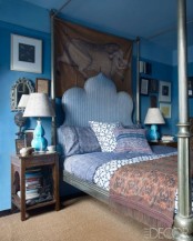 a Moroccan fele is given to the bedroom with a whimsy blue bed, carved wooden tables and ornate mirrors
