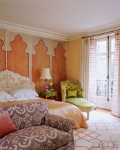a colorful Moroccan bedroom done in rust, purple, neutrals and mustard and with traditional prints