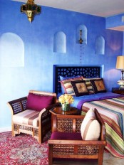 a carved bed and chairs, a Moroccan lantern and colorful printed textiles