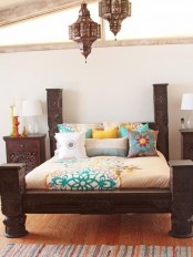 dark carved wooden furniture, Moroccan lanterns and colorful bedding to create a modenr Eastern sleeping space