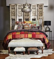 an ornate wooden screen, elegant ottomans and bright printed textiles plus a hanging metal lantern