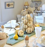 white pumpkins in a cage and gourds are great to style your Thanksgiving table and make it chic and cool