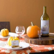 a wood slice as a stand, orange pumpkins and gourds are what you need to make your tablescape feel very cozy and natural
