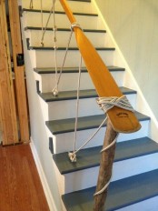 a nautical staircase in grey and white, with an oar rail and rope that holds it looks out of the box