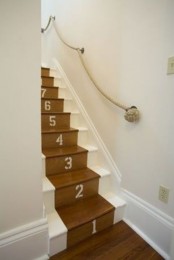 a nautical staircase, stained and white, with a thick rope rail attached to the wall is a cool idea