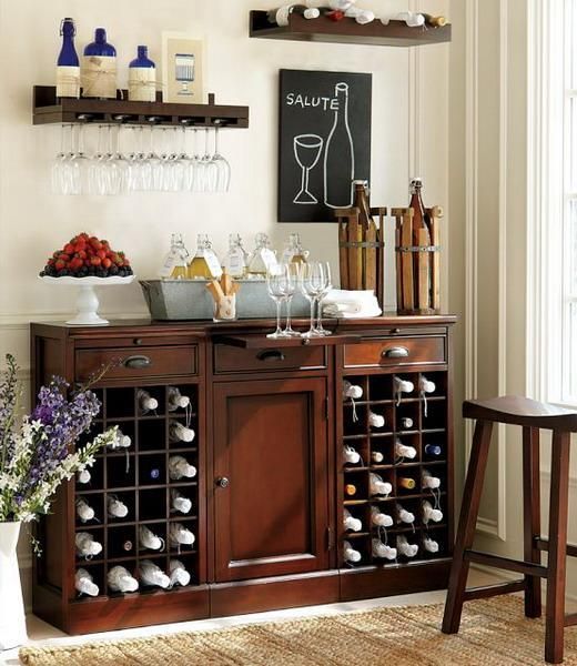 An elegant dark stained home bar with open shelves, a stool and lots of wine and other bottles in the comfortable storage units is a stylish idea for a vintage space