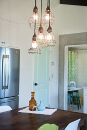 a cluster of metal pendant lamps with a rusty touch is a great solution for a rustic or vintage space, they can fit an industrial one, too