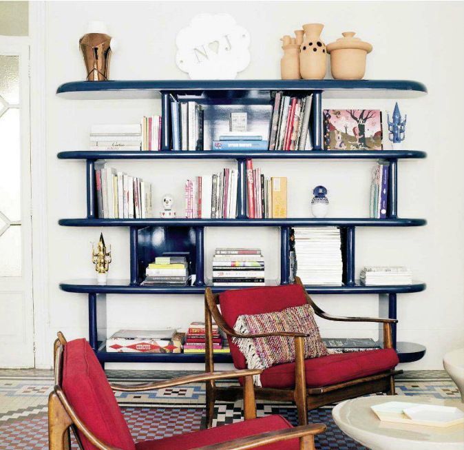 A mid century modern book case made of shiny navy blue panels will add color to your room