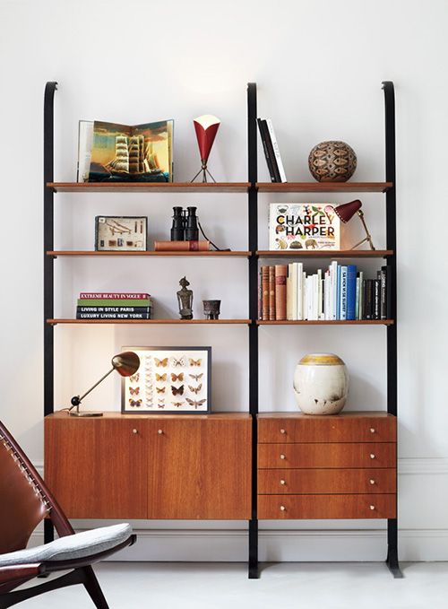 A mid century modern bookcase of metal and rich stained wooden shelves and drawers is a stylish idea that doesn't take any floor space