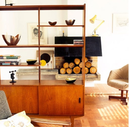 A bright shaded wooden mid century modern bookcase with shelves and closed storage cabinets