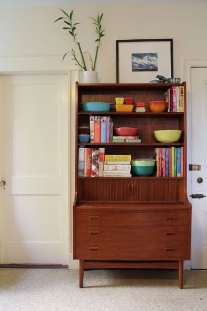 A brown wood mid century modern bookcase with open shelves and some drawers can be also used as a desk