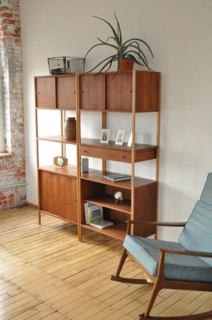 A rich stained mid century modern bookcase with closed cabinets, drawers and open shelving