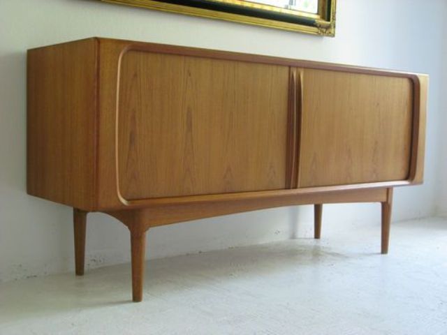 A light stained mid century modern sideboard with sliding doors and carved touches on tall legs is a cool idea for a modern space