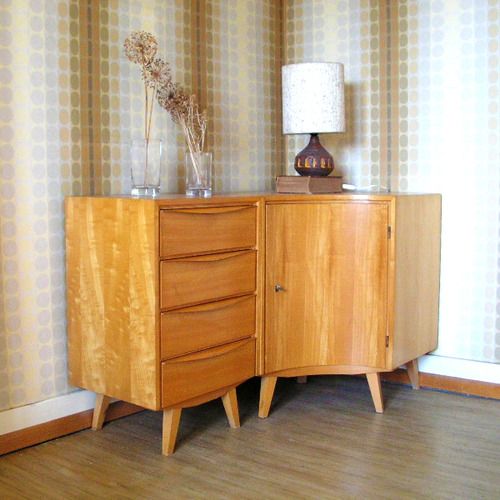 A curved light stained mid century modern sideboard with drawers and a door is a very catchy solution for a corner in your space