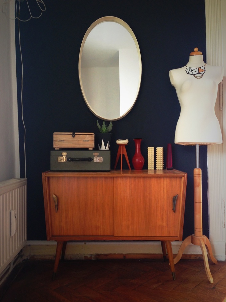 A small and cute mid century modern sideboard with sliding doors with big handles and on tall legs is a lovely idea