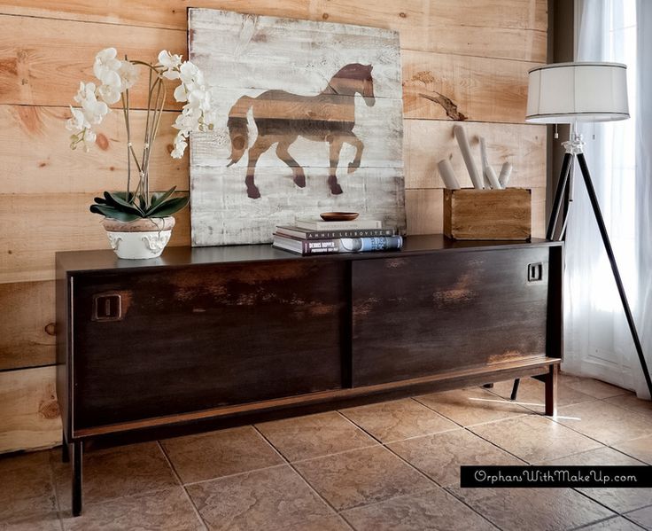 A dark stained sideboard with sliding doors with cutout handles and on tall legs will make a statement in your space adding color and a contrasting touch if it's not dark